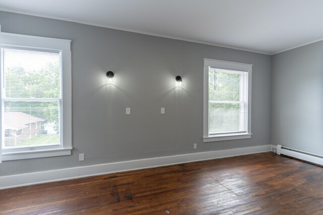 unfurnished room with dark wood-style floors, a baseboard heating unit, ornamental molding, and baseboards