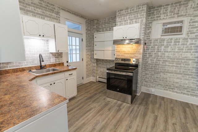 kitchen featuring a baseboard heating unit, stainless steel electric stove, under cabinet range hood, white cabinetry, and a sink