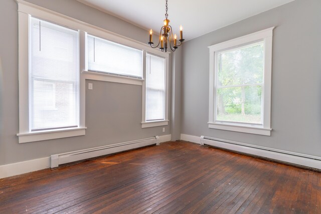 spare room with an inviting chandelier, a baseboard heating unit, and dark wood-style flooring