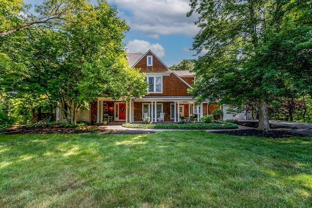 shingle-style home with covered porch and a front lawn