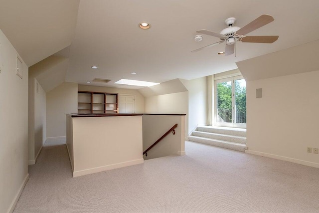 additional living space with ceiling fan, recessed lighting, light colored carpet, baseboards, and lofted ceiling with skylight