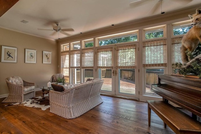 interior space with ceiling fan, visible vents, ornamental molding, and hardwood / wood-style floors