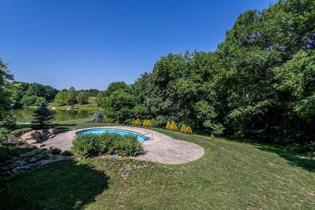 outdoor pool featuring a water view, a patio area, and a yard