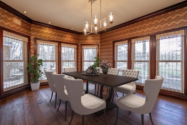 dining space featuring a chandelier, ornamental molding, dark wood-style floors, and wallpapered walls