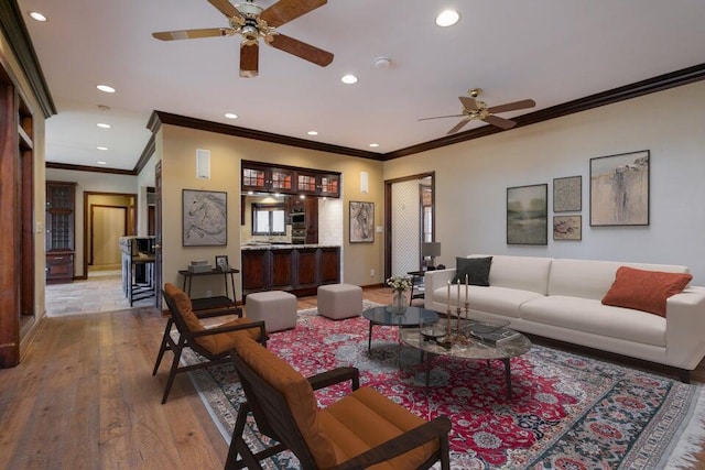 living area with ceiling fan, recessed lighting, baseboards, ornamental molding, and wood-type flooring