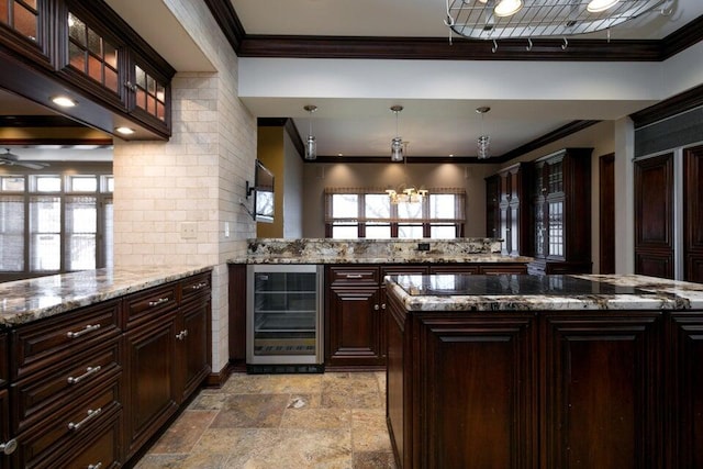 bar featuring beverage cooler, stone finish flooring, a ceiling fan, and crown molding