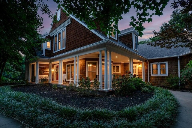 back of property with covered porch and roof with shingles