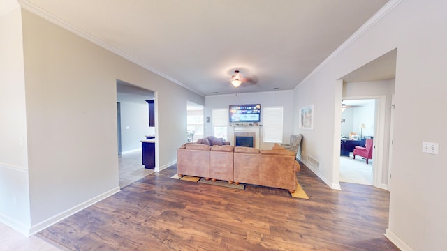 living room with ceiling fan, dark wood-type flooring, and ornamental molding