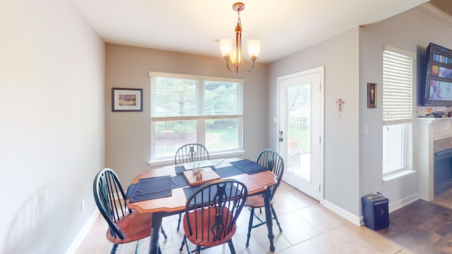 tiled dining area featuring a chandelier and a tiled fireplace