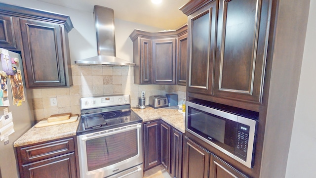 kitchen with light stone counters, wall chimney range hood, stainless steel appliances, and tasteful backsplash