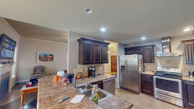 kitchen featuring dark brown cabinetry, sink, wall chimney exhaust hood, and appliances with stainless steel finishes