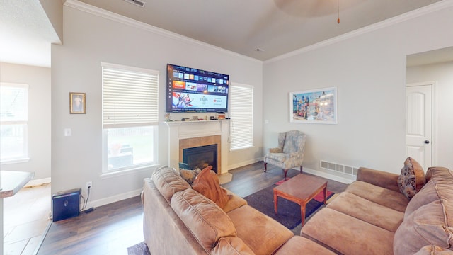 living room featuring a tiled fireplace, crown molding, dark hardwood / wood-style flooring, and ceiling fan