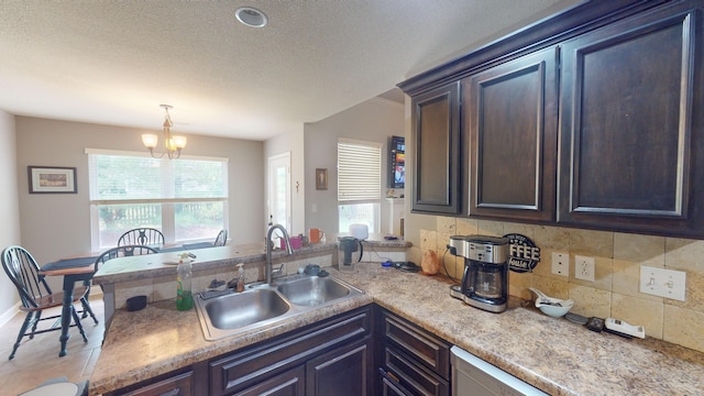 kitchen featuring tasteful backsplash, dark brown cabinets, sink, an inviting chandelier, and hanging light fixtures