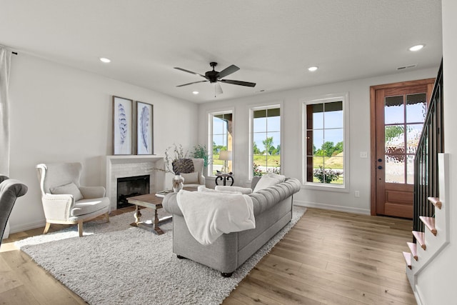 living room with light hardwood / wood-style floors and ceiling fan