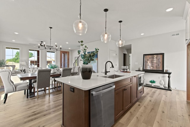 kitchen featuring pendant lighting, sink, a chandelier, stainless steel appliances, and light wood-type flooring