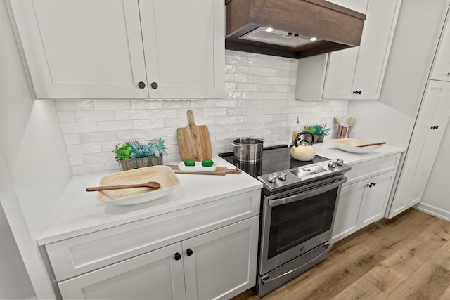 kitchen featuring light hardwood / wood-style floors, white cabinets, stainless steel range with electric cooktop, and custom exhaust hood