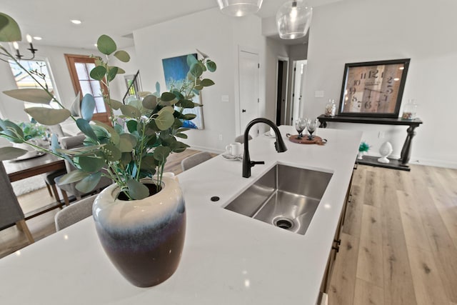 details with pendant lighting, sink, and light hardwood / wood-style floors