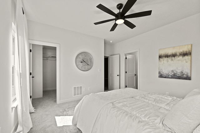 carpeted bedroom featuring a spacious closet, ceiling fan, and a closet