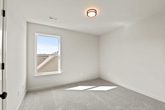 spare room with a textured ceiling and carpet flooring