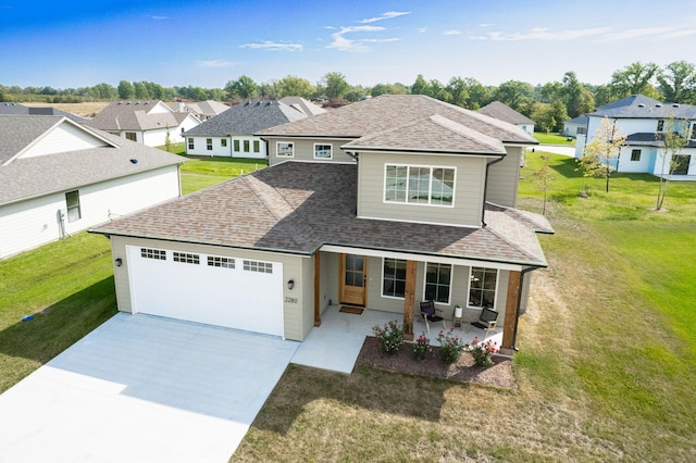 view of front of home featuring a porch, a garage, and a front yard