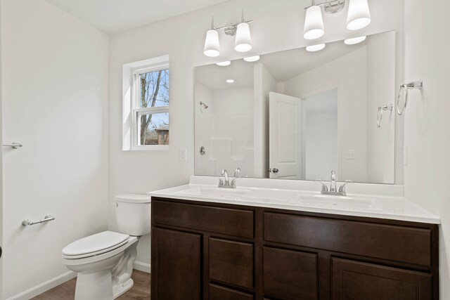 bathroom with hardwood / wood-style floors, vanity, and toilet