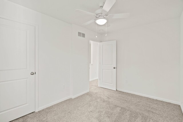 empty room featuring ceiling fan and light colored carpet