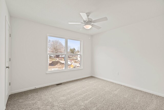 carpeted spare room with ceiling fan