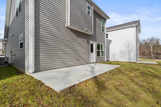 rear view of house featuring a yard, a patio, and central AC unit