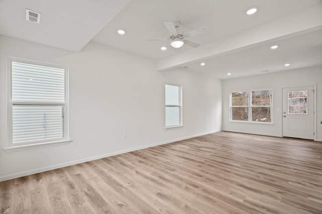 spare room with ceiling fan, light hardwood / wood-style flooring, and beamed ceiling