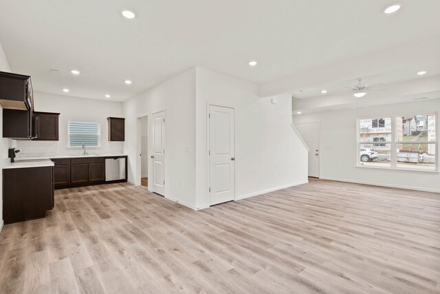 unfurnished living room featuring ceiling fan, sink, and light hardwood / wood-style flooring