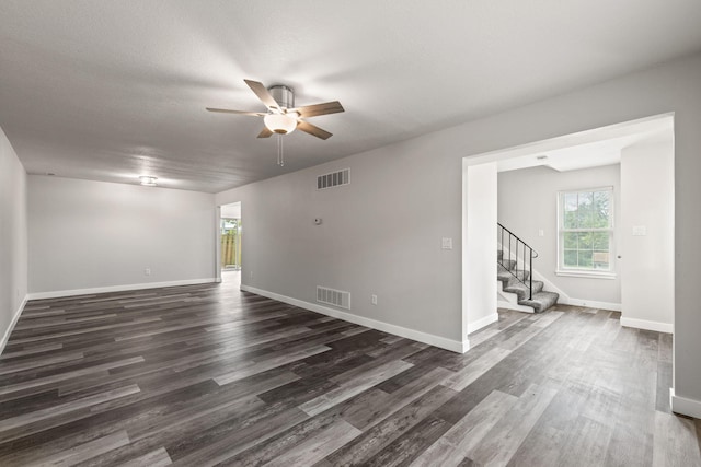 unfurnished room with a textured ceiling, dark wood-type flooring, and ceiling fan