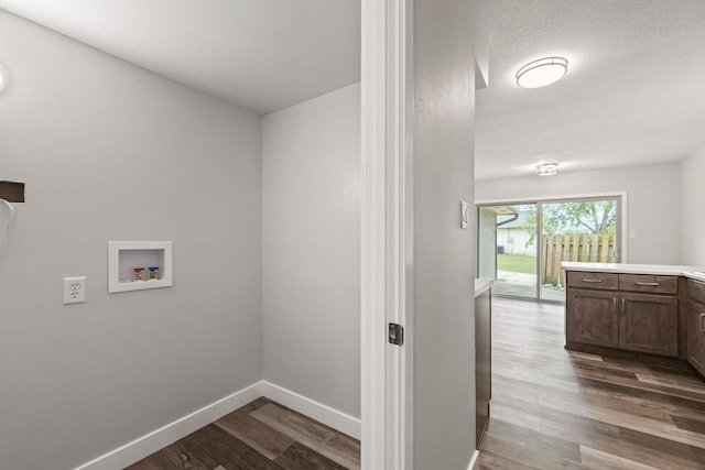 laundry room with washer hookup, light hardwood / wood-style flooring, and a textured ceiling