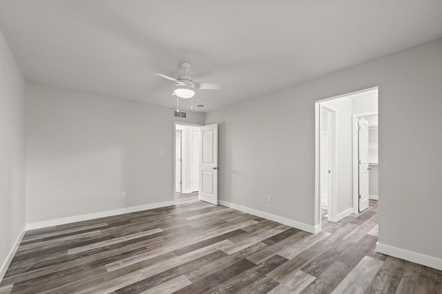 spare room featuring dark wood-type flooring and ceiling fan