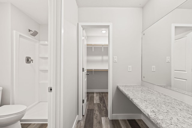 bathroom featuring wood-type flooring, a shower, and toilet