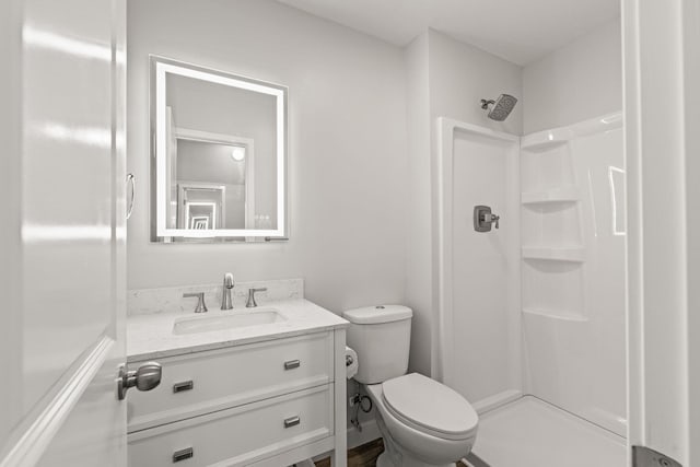 bathroom with vanity, toilet, and a shower