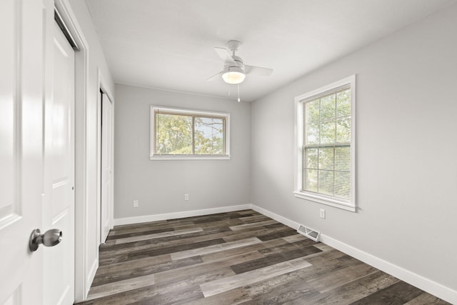 unfurnished bedroom featuring dark hardwood / wood-style floors, ceiling fan, and a closet