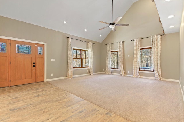 foyer entrance with ceiling fan, high vaulted ceiling, light wood-style flooring, and baseboards