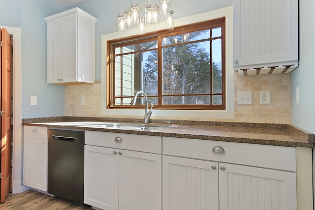 kitchen featuring black dishwasher, dark countertops, pendant lighting, and white cabinetry