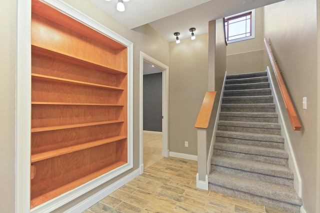 staircase with baseboards and wood finished floors