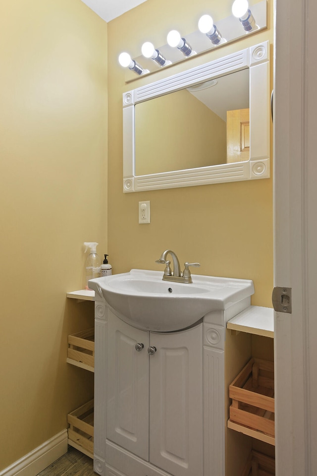 bathroom with wood finished floors, vanity, and baseboards