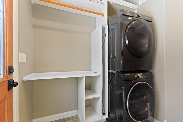 washroom with laundry area, baseboards, and stacked washer and clothes dryer