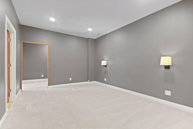 spare room with light carpet, recessed lighting, and baseboards