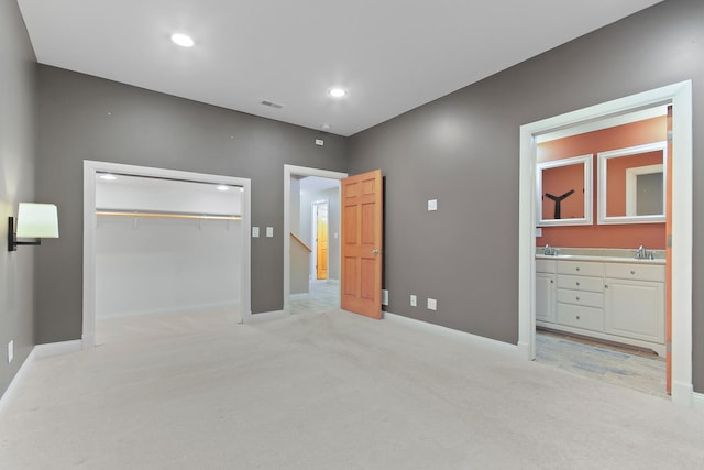 bedroom featuring light carpet, a closet, visible vents, and a sink