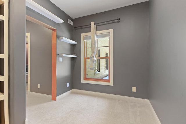 empty room with baseboards, visible vents, and light colored carpet