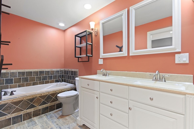 bathroom featuring a garden tub, double vanity, a sink, and toilet