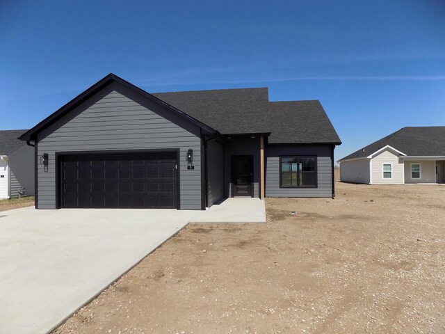 5 Carnival Ln, Centralia, MO 65240 - view of front of house featuring roof with shingles, an attached garage, and concrete driveway