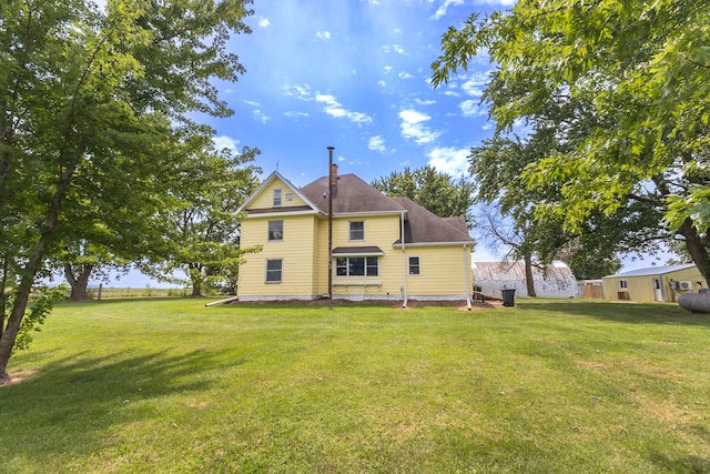 rear view of house featuring a yard