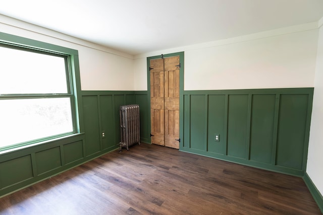 spare room with radiator and dark hardwood / wood-style flooring