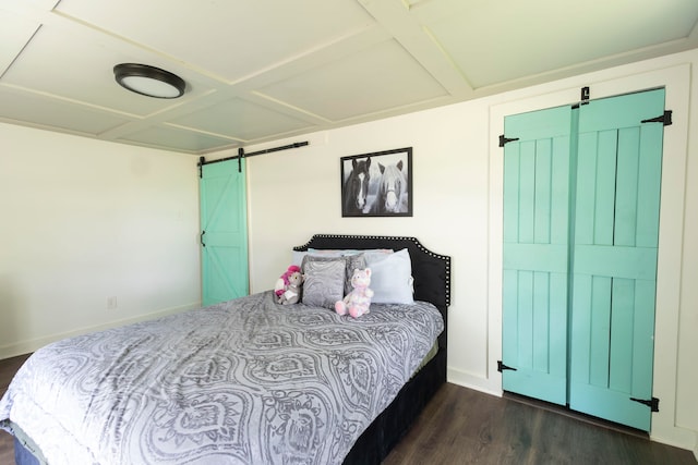 bedroom with coffered ceiling, dark hardwood / wood-style floors, and a barn door