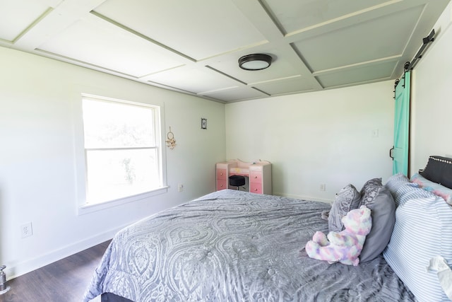 bedroom featuring a barn door, coffered ceiling, and dark hardwood / wood-style flooring